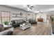 Spacious living room featuring plank flooring, abundant natural light, ceiling fans, and neutral colored walls at 16118 W Port Au Prince Ln, Surprise, AZ 85379