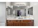 Vanity in main bathroom featuring double sinks and an oversized mirror and vanity lights at 16118 W Port Au Prince Ln, Surprise, AZ 85379