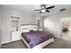 Bright main bedroom with a ceiling fan, carpet floors, and two windows with wooden blinds at 16118 W Port Au Prince Ln, Surprise, AZ 85379