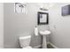 Cozy powder room with a pedestal sink, toilet, and wall decorations at 16118 W Port Au Prince Ln, Surprise, AZ 85379