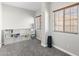 Well-lit room with two windows, gray carpet flooring, and built-in shelves at 16118 W Port Au Prince Ln, Surprise, AZ 85379