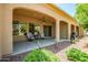 Covered patio overlooks backyard featuring easy to maintain desert landscaping with mature trees at 16426 W Piccadilly Rd, Goodyear, AZ 85395