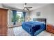 Bedroom with window view, blue bedding and flooring, complete with fan and dresser at 16426 W Piccadilly Rd, Goodyear, AZ 85395