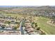 Wide aerial view of homes and community showing nearby golf course, surrounding desert landscape, and mountain views at 18199 W Buckhorn Dr, Goodyear, AZ 85338