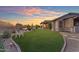 Lush backyard with manicured lawn, patio area, and desert plants, offering an ideal space for relaxation and entertainment at 18199 W Buckhorn Dr, Goodyear, AZ 85338