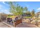 Serene backyard retreat with mature landscaping, stone accents, and comfortable seating area at 18199 W Buckhorn Dr, Goodyear, AZ 85338