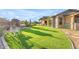 Expansive backyard with artificial turf, patio, and outdoor kitchen perfect for entertaining at 18199 W Buckhorn Dr, Goodyear, AZ 85338