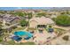 Aerial view of backyard with pool, spa, fire pit, covered patio, outdoor seating, lush landscaping, desert landscaping at 18199 W Buckhorn Dr, Goodyear, AZ 85338