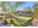 Beautiful backyard featuring a putting green, mature trees and rock features at 18199 W Buckhorn Dr, Goodyear, AZ 85338