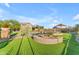 Beautiful backyard features a fire pit, pool with rock features, lush turf, and picturesque desert landscaping at 18199 W Buckhorn Dr, Goodyear, AZ 85338