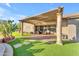 Covered patio with seating area, landscaping and view to the backyard and the home at 18199 W Buckhorn Dr, Goodyear, AZ 85338