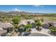 Aerial view of charming home showing desert landscaping, tile roof, three-car garage, and golf course in the background at 18199 W Buckhorn Dr, Goodyear, AZ 85338