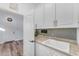 Bright laundry room with granite countertops, sink, and white cabinets, offers functionality and ample storage space at 18199 W Buckhorn Dr, Goodyear, AZ 85338