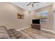 Inviting living room with wood flooring, ceiling fan, and a comfortable couch at 18199 W Buckhorn Dr, Goodyear, AZ 85338