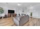 Comfortable living room with hardwood floors, large TV, and cozy gray sofa at 18199 W Buckhorn Dr, Goodyear, AZ 85338