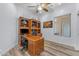 Inviting office featuring wood-look flooring, ceiling fan, natural light, and a spacious desk area at 18199 W Buckhorn Dr, Goodyear, AZ 85338