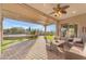 Covered patio with seating area and a view of the landscaped backyard and pool at 18199 W Buckhorn Dr, Goodyear, AZ 85338