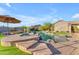 Gorgeous backyard featuring a sparkling pool, lush landscaping, and stone accents for serene outdoor living at 18199 W Buckhorn Dr, Goodyear, AZ 85338