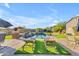 Relaxing poolside with comfortable lounge chairs, lush green turf, and a serene view of the sparkling pool at 18199 W Buckhorn Dr, Goodyear, AZ 85338