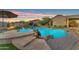 Resort-style pool with rock accents, mature landscaping, and a cozy fire pit, creating a perfect outdoor retreat at 18199 W Buckhorn Dr, Goodyear, AZ 85338