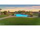 Lush backyard featuring a stunning pool, inviting lounge areas, and desert landscaping for outdoor living at 18199 W Buckhorn Dr, Goodyear, AZ 85338