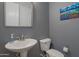 Clean half bathroom with a pedestal sink, modern fixtures, and a mountain themed wall art at 18837 W San Juan Ave, Litchfield Park, AZ 85340