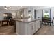 Kitchen island with seating, stainless appliances, and open concept to dining and living areas at 18837 W San Juan Ave, Litchfield Park, AZ 85340