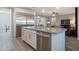 Modern kitchen showcasing a large island with a sink, and stainless steel appliances at 18837 W San Juan Ave, Litchfield Park, AZ 85340