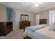 Spacious main bedroom featuring dark wood furniture, carpet, soft blue accents and plenty of soft natural light at 18837 W San Juan Ave, Litchfield Park, AZ 85340