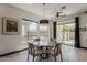 A dining room with a round table is situated near large windows and a sliding glass door to the backyard at 199 E Tangerine Path, Queen Creek, AZ 85140