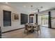 A dining room with a round table is situated near large windows and a sliding glass door to the backyard at 199 E Tangerine Path, Queen Creek, AZ 85140