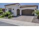Exterior shot showing a two-car garage with arched doors and a well-maintained paved driveway at 199 E Tangerine Path, Queen Creek, AZ 85140