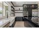 Bright kitchen with an apron sink, open shelving, and black cabinetry at 199 E Tangerine Path, Queen Creek, AZ 85140