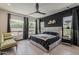 Spacious main bedroom with elegant decor, black accent wall, and large windows providing lots of light at 199 E Tangerine Path, Queen Creek, AZ 85140