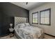 A cozy main bedroom with a tufted headboard, marble patterned bedding, and dark wall accent at 199 E Tangerine Path, Queen Creek, AZ 85140