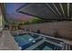 An inviting pool featuring a modern pergola and tranquil fireplace under a vivid twilight sky at 199 E Tangerine Path, Queen Creek, AZ 85140