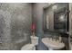 Stylish powder room featuring mosaic tile wall, elegant vanity, modern sink, and decorative mirror and wall paint at 199 E Tangerine Path, Queen Creek, AZ 85140