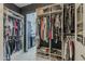 Luxurious walk-in closet with custom shelving, hanging racks, shoe storage, and access to the ensuite bathroom at 199 E Tangerine Path, Queen Creek, AZ 85140