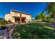 Large backyard featuring green lawn, patio seating, mature trees, desert landscaping and stucco exterior at 2004 N 125Th Ave, Avondale, AZ 85392
