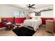 Cozy bedroom featuring half-painted red walls, a window, an area rug, and a comfortable chair for relaxation at 2004 N 125Th Ave, Avondale, AZ 85392