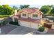 Exterior aerial view of a home featuring a red tile roof, three car garage and landscaped yard at 2004 N 125Th Ave, Avondale, AZ 85392