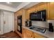 This kitchen offers wood cabinetry, built-in oven and microwave, plus a cooktop for all of your cooking needs at 2004 N 125Th Ave, Avondale, AZ 85392
