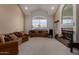 Spacious living room featuring neutral carpet, a fireplace, and a vaulted ceiling with large windows at 2004 N 125Th Ave, Avondale, AZ 85392