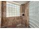 This shower features glass block and gorgeous tiles for a spa-like experience at 2004 N 125Th Ave, Avondale, AZ 85392