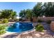 Sparkling backyard swimming pool features lush landscaping, with stone accents and mature palm trees at 2004 N 125Th Ave, Avondale, AZ 85392