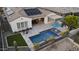 Aerial view of backyard featuring pool, outdoor kitchen, turf area, pergola, solar panels, and desert plants at 20595 W Pasadena Ave, Buckeye, AZ 85396