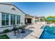 Elegant back patio with a pool, outdoor kitchen, and bar stool seating area at 20595 W Pasadena Ave, Buckeye, AZ 85396