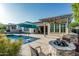 Well-appointed backyard featuring a pool, patio cover, fire pit and lush landscaping at 20595 W Pasadena Ave, Buckeye, AZ 85396