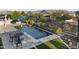 Beautiful pool with a waterfall feature, surrounded by desert landscaping, with an outdoor table and chairs at 20595 W Pasadena Ave, Buckeye, AZ 85396