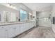 Bright bathroom featuring a double vanity, large mirror, walk-in shower and wood-look tile flooring at 20595 W Pasadena Ave, Buckeye, AZ 85396